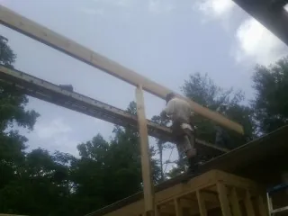 Carpenter setting a ridge beam over a new addition frame — Ice Dam Removal by Roofing Brothers in Dudley