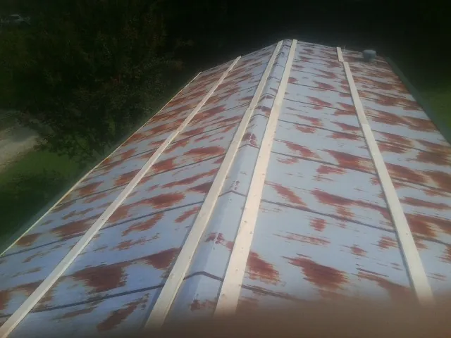 Rusted metal roof panels with new wood purlins before replacement — Storm Damage Roof Repair in Dudley by Roofing Brothers
