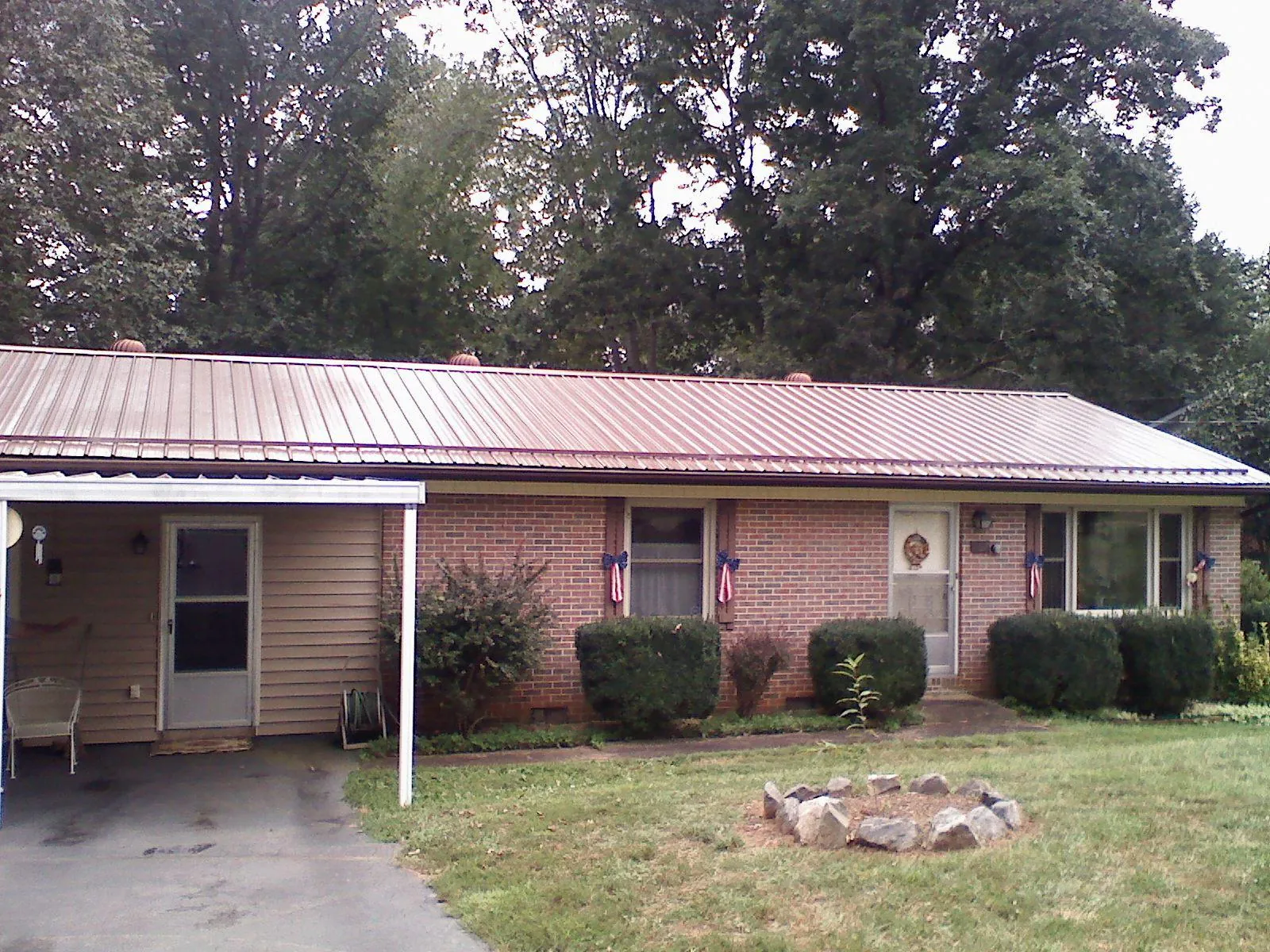 Bronze metal roof and carport on a brick ranch home — Roof Repair work by our crew in Dudley